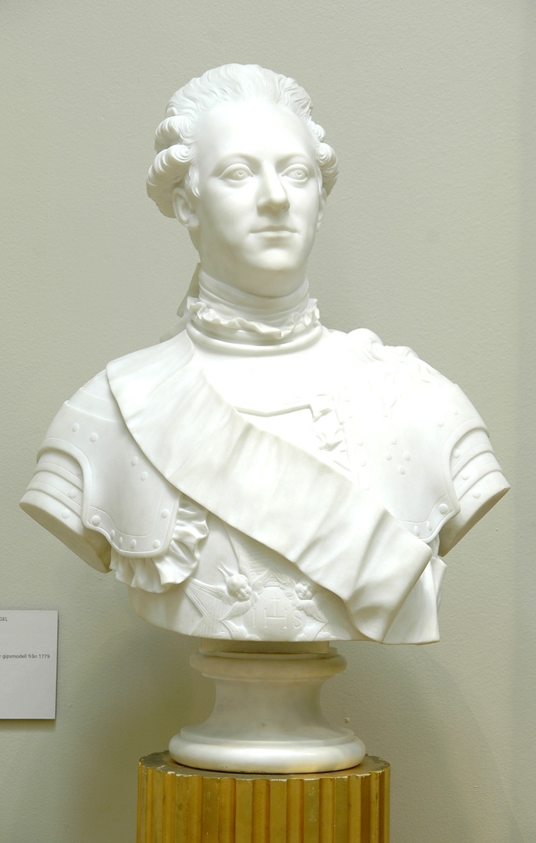 Marmorbyst föreställande Kung Gustav III, "Copia fatta da M. Bacci. Florens", dvs marmorkopia efter gipsoriginal av J T Sergel från 1779. Står på hög gustaviansk piedestal, med vertikala hålkäler och lagerkrans nertill kring foten. Piedestalen står på lågt fyrkantigt podium.
Kopia utförd av M. Bacci Florens. Montering/Ram: Originalpiedestal från ca 1800