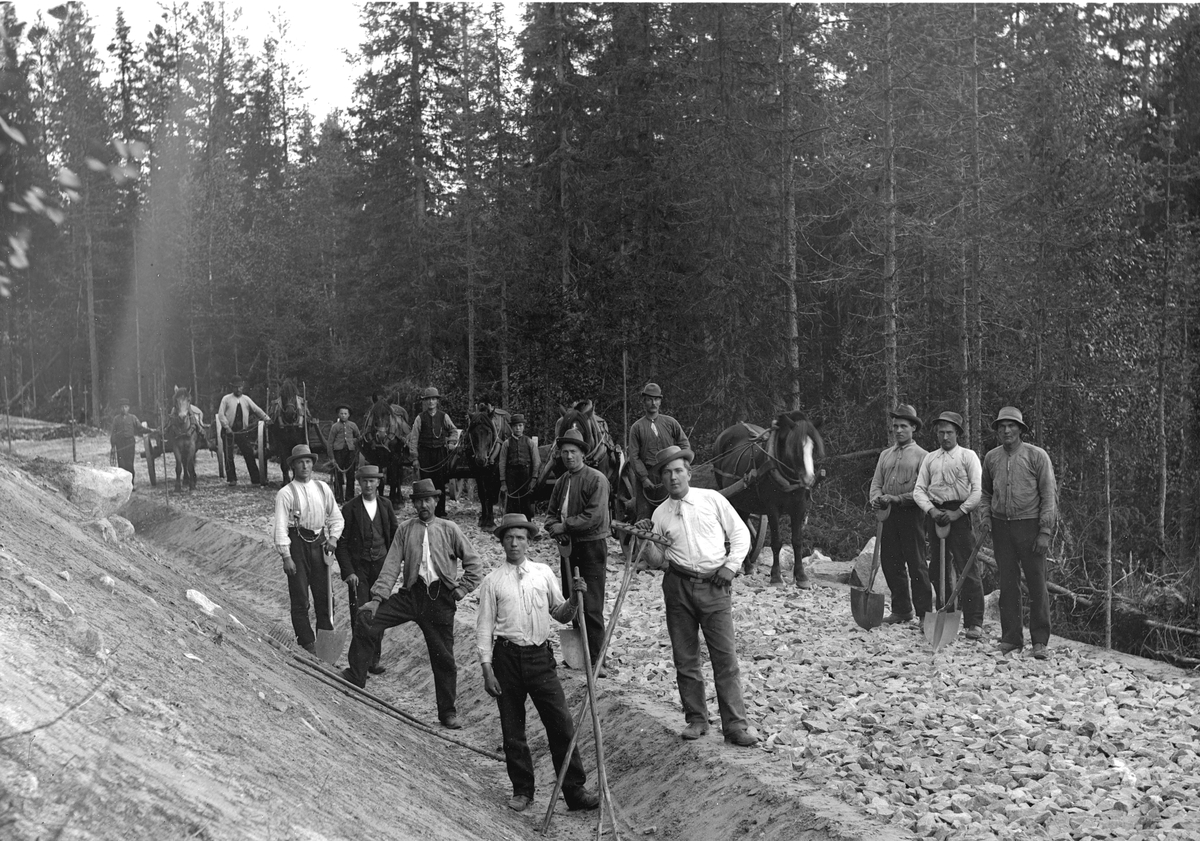 Dokumentasjon av arbeid med et veiprosjekt, ant i Trysil. Ukjente arbeidere. Vegbygging. Dessverre har vi ikke fått bekreftet opplysninger om hvilket prosjekt det er, men det kan være fra 1913, og bygging av vegen mellom Nybergsund og Innbygda.