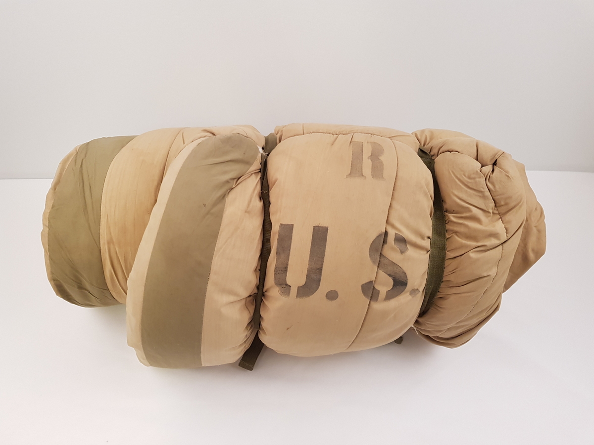 Beige og grønn feltsovepose til bruk om vinteren.