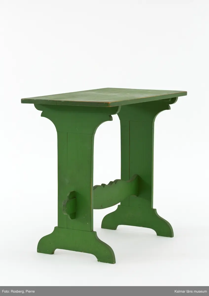 KLM 31918. Bord. Av trä, furu. Bord med två enkelståndare förenade med en profilerad regelbom. Ståndarna är nederst förgrenade på två fötter. Målad i grön färg.