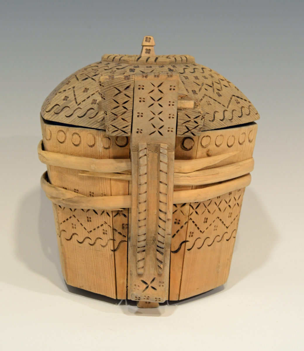 Fra katalog: Ottekantet smørkande og stav med hank og laak og tre smaa føtter, utvendig svimerket og en slynget ring oppe paa laaket, indvendig
rik rosette. Under staar brændemerket: A OSS 1823,