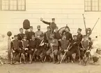 Officerssällskap bestående av husarer, dragoner, infanterister och artillerister poserar framför K2:s förläggning på Ladugårdsgärde under sabelfäktningskurs 1890.