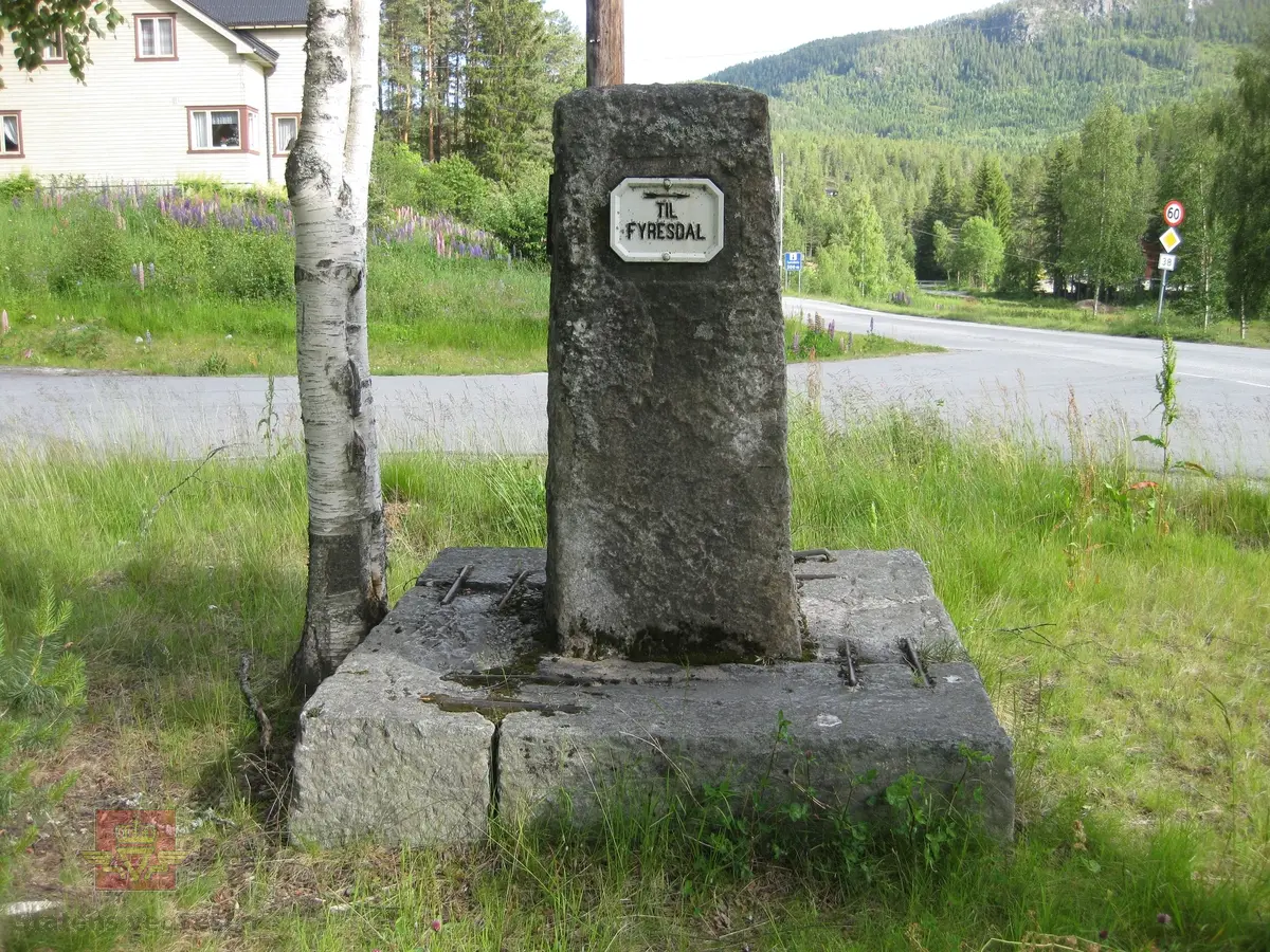 "Ved Krosli 09.08.1926", i følge merking på bildet. På bildet står et stort betongvegmerke med innhugget årstall: "Gjennem Vraadal 1904". Damen på bildet er muligens Christine Baalsrud, vegdirektørens kone. Han står til høyre for henne med skyggelue. Personene nr. 3 og nr. 6 fra venstre er de samme  som er avbildet på bilde NVM 00-F-3579. De er ukjente. 

De neste bildeframvisningene i farger viser "Vegmerke i Krossli." Sitat gjengitt fra Krossli-lokalhistoriewiki.no. Foto: Olav Momrak Haugan: "Krossli er eit vegkryss i Tokke kommune som ligg på vegen frå Bandaksli til Fyresdal. I 2011 går Rv 355 nordover frå Fyresdal til Krossli. Bandakslivegen, vegen fra Bandaksli til Fyresdal, vart i fyste del av 1900-talet grundig utbedra. Frå denne perioden finnast det fleire vegmerke som fortel vegfarande kor vegen fører vidare. Ei slik støtte stod midt i krysset i Krossli, i 2011 står den i utkanten av krysset. Litt lenger sør vert ein gjort merksam på at ein kryssar grensa til Fyresdal, etter fyrst å ha vore eit lite stykke gjennom Kvitseid kommune". 

Ref. til verneplanen "Vegvalg-Nasjonal verneplan for veger, bruer og vegrelaterte kulturminner. Statens vegvesen-Region Sør". Jfr. "202 Bandaksli", side 206. Se vedlegg.