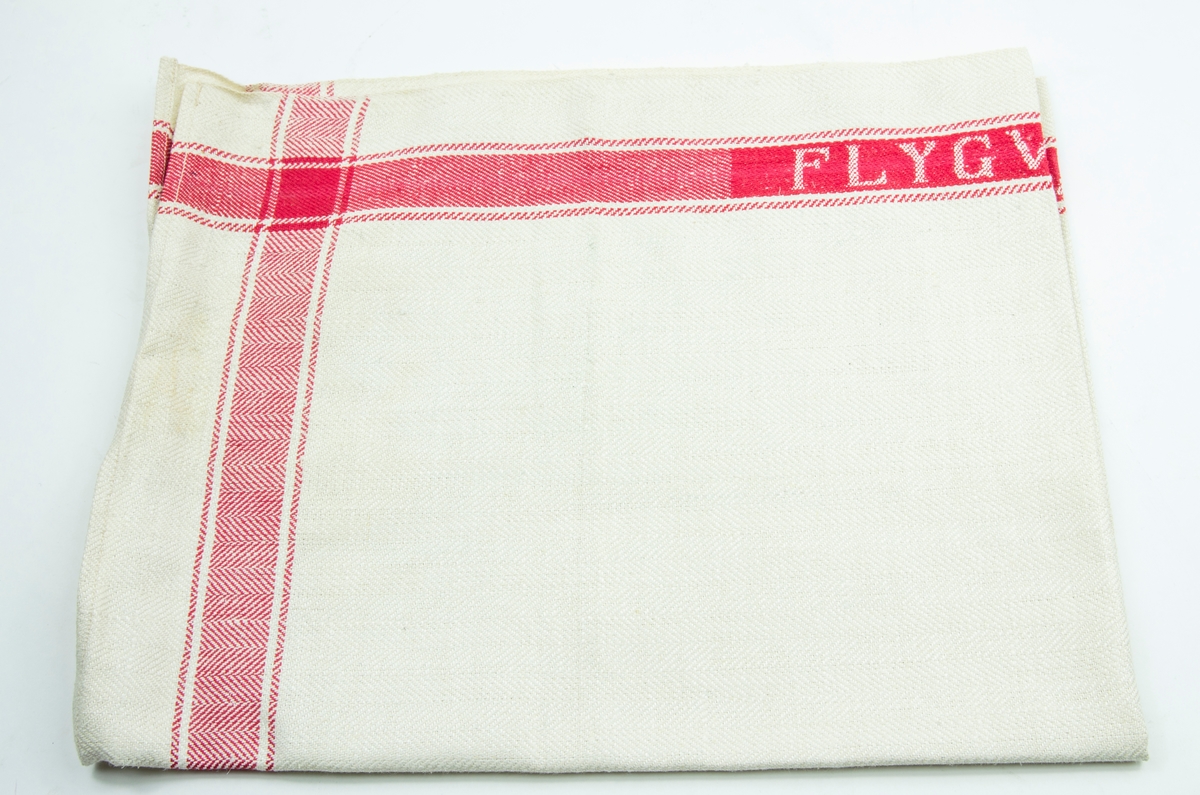 Linnehandduk med röda bårder. På lånsidorna är "Flygvapnet" invävt i bården.