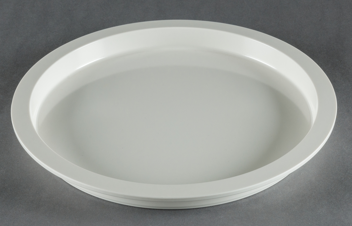 Tallrikar, gjutna i vit plast, 4 stycken. Modell "Plastic Medley". Helt flata med vertikala sidor, upptill avslutade med bred kant. Design Gunnar Cyrén. Tillverkad för Dansk Designs Ltd, USA.