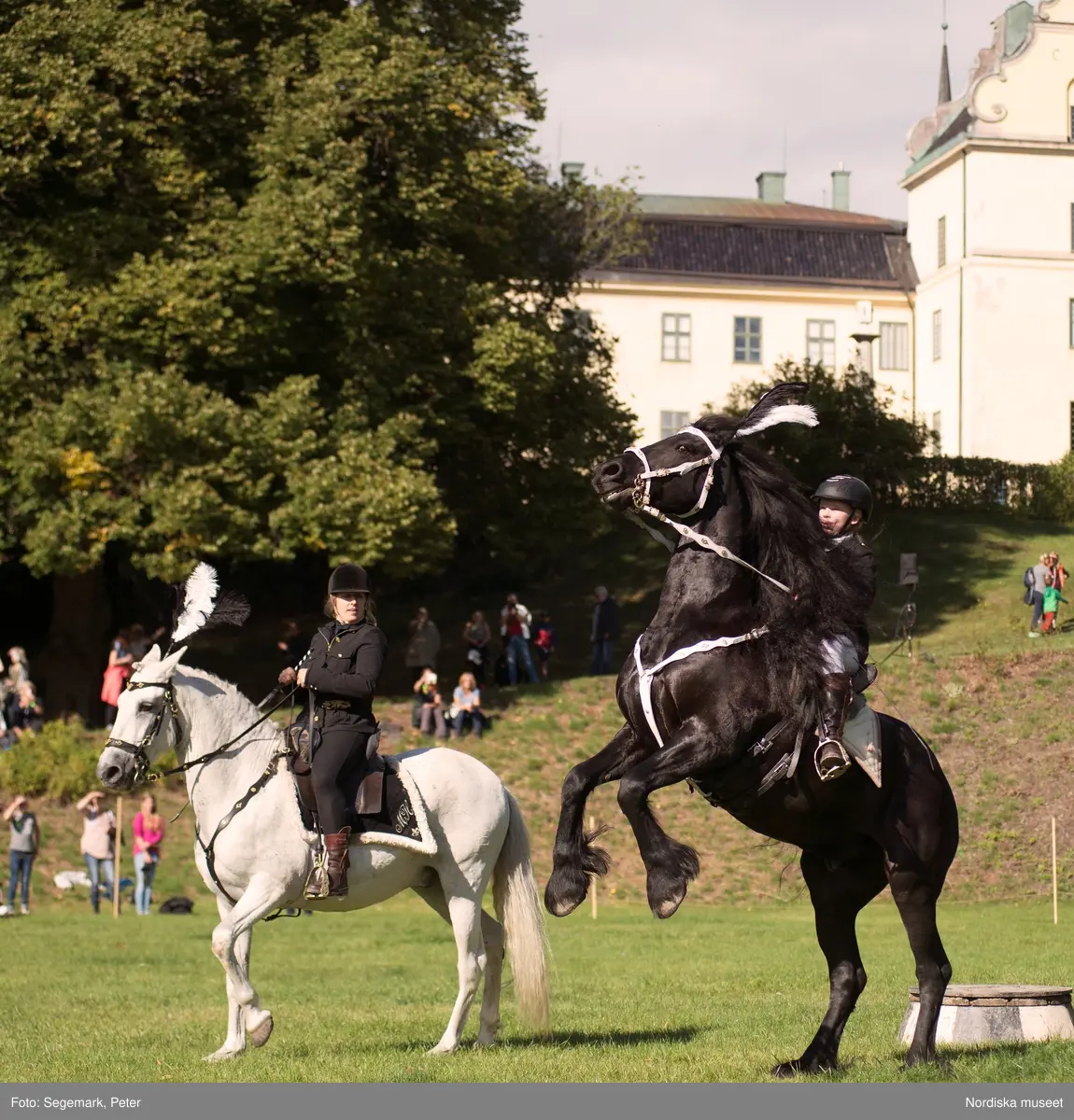 Hästfesten på Tyresö slott med konferencier Owe Sandström, Slottshästen. Hästar, ryttare och ekipage med vagn eller käpphäst tävlar och visar upp sig i parken bland åskådare som besöker evenemanget.