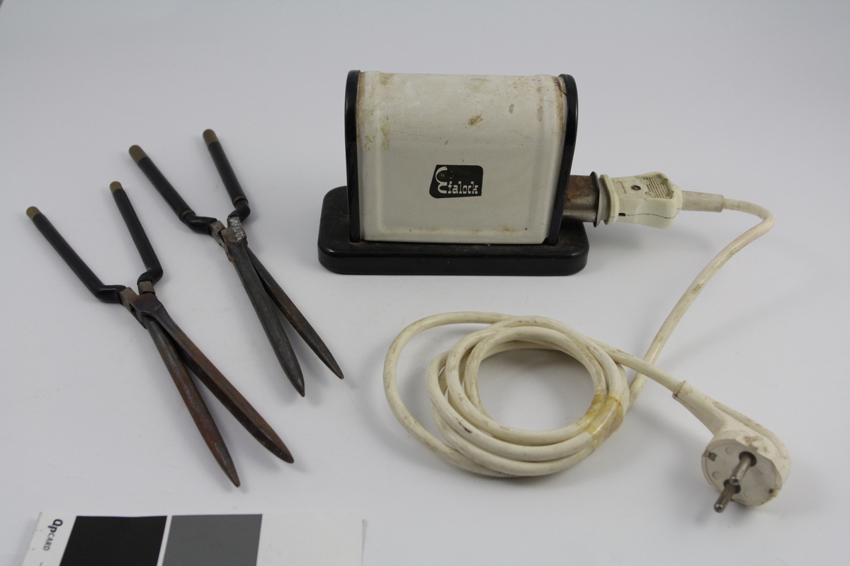 Eletrisk krølltang bestående av fire deler:
a-b) krølltenger: 2 stk. sylindriske håndtak (a kan beveges).  Når håndtakene føres sammen, presses sylinder i andre enden ned i hul del. 
c) elektrisk varmeapparat, uttak støpsel og ledning på den ene siden. Rektangulær sokkel. Påsatt rektangulær del med avrundet overside. Kortside: inntak for to krølltenger. Oval åpning. 
d) Ledning med kontakter.