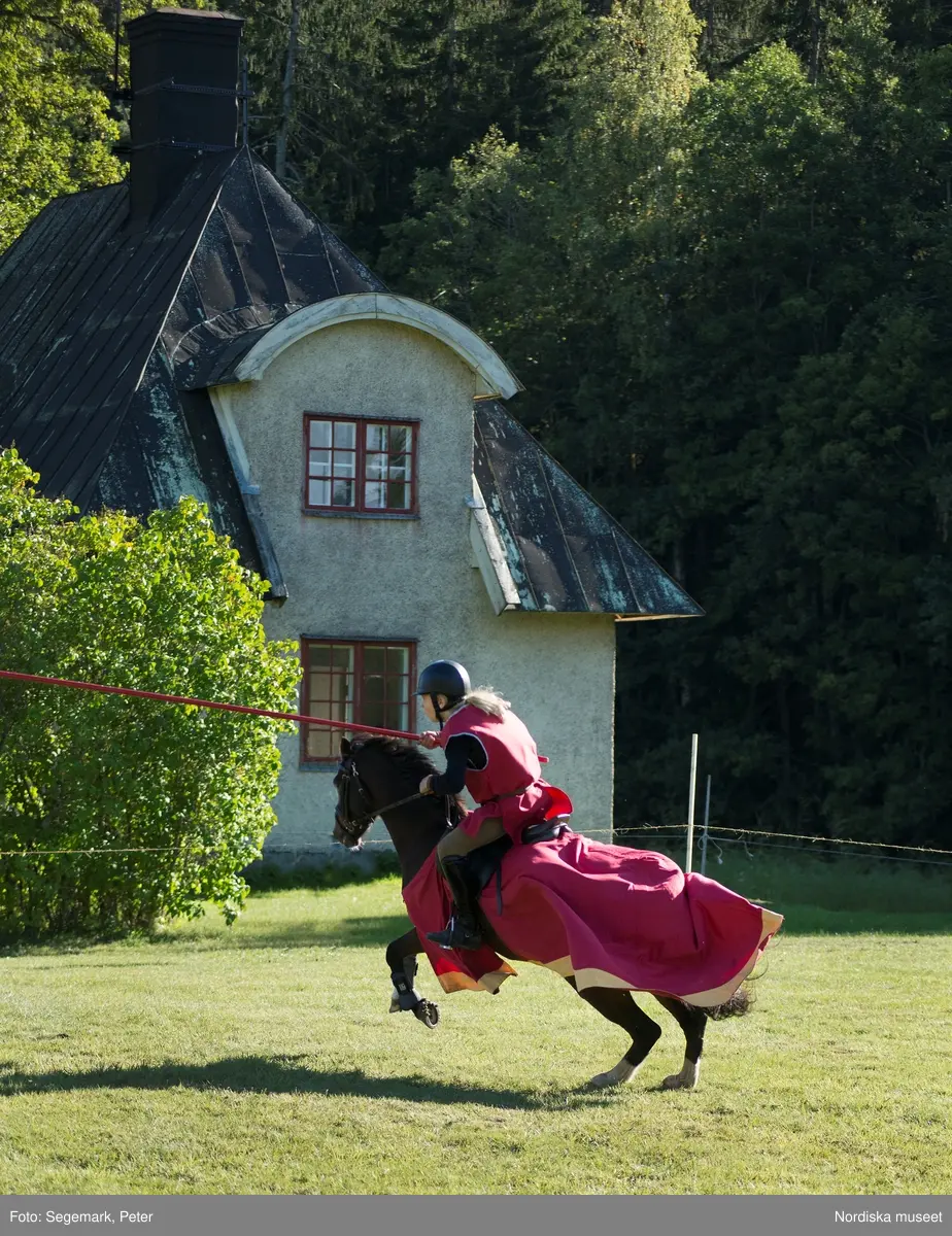 Hästfesten på Tyresö slott med konferencier Owe Sandström, Slottshästen. Hästar, ryttare och ekipage med vagn eller käpphäst tävlar och visar upp sig i parken bland åskådare som besöker evenemanget.
