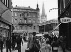 Folkvimmel i Linköping 1975. Vy från Tanneforsgatan mot Stora torget. I fonden markerar Jonn O Nilsons hus och det nyinvigda varuhuset Filbyter tydligt olika tidsepoker.