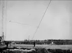 Karlsborgs radiostation i Kråk. Från mastresningen, år 1916. Masterna är konstruerade av professor K Ljungberg, Stockholm, var 210 m höga och vägde 25 ton. Foto: Alfred Sjöberg, Karlsborg. Masterna revs i mars år 2001.