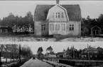 Karlsborg, Storgatan. Övre byggnaden är byggt år 1924 och finns fortfarande kvar. Nedre bildens byggnader är rivna. Fotot är taget omkr 1930. Kortet finns ej på museet.