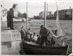 Befäl i samspråk med män i segelbåt.