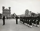 Militärer poserar på torget, matroser i bakre ledet och sjöbefälen framför. I bakgrunden syns Fredrikskyrkan.