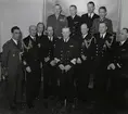 Konteramiral Samuelson (i mitten) och kommendörkapten Lind af Hageby (tredje från vänster) poserar för ett gruppfoto tillsammans med en kommendörkapten, flera kaptener och höga militärer.