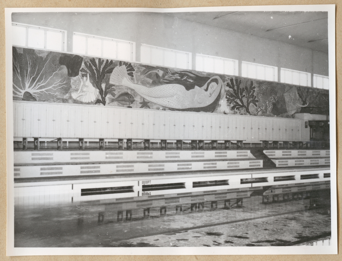 Simbassängen på Sparre Simhall, interiört. I bakgrunden syns en muralmålning ovanför en rad skåp föreställande en sjöjungfru omgiven av fisk och koraller. Konstnär: Erik Ahl????