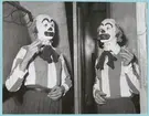 Bakom en scen står två människor i clowndräkter och clownsmink. De håller båda i var sin cigarett. Posten är daterad till 14-12-51.