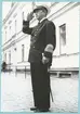 Konteramiral Samuelson, klädd i uniform, står utanför bataljon Sparres kanslibyggnad och gör honör.