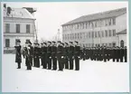 Uniformsklädda flottister står uppställda på bataljon Sparres snötäckta kaserngård.