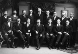 Foto av en gruppe staselig kledte menn. Det er ukjent hvem v