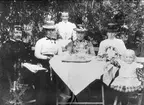 Karlsborg 1901, kaffepaus i trädgården. Bataljonsläkare och fru J.O. Nordlander. Stående hembiträdet Lotten Boström (från Fagersanna?), fröken Carolina Olsén, Sundsvall. Fru Elisabeth och pastor C.A. Nordlander med dotter.