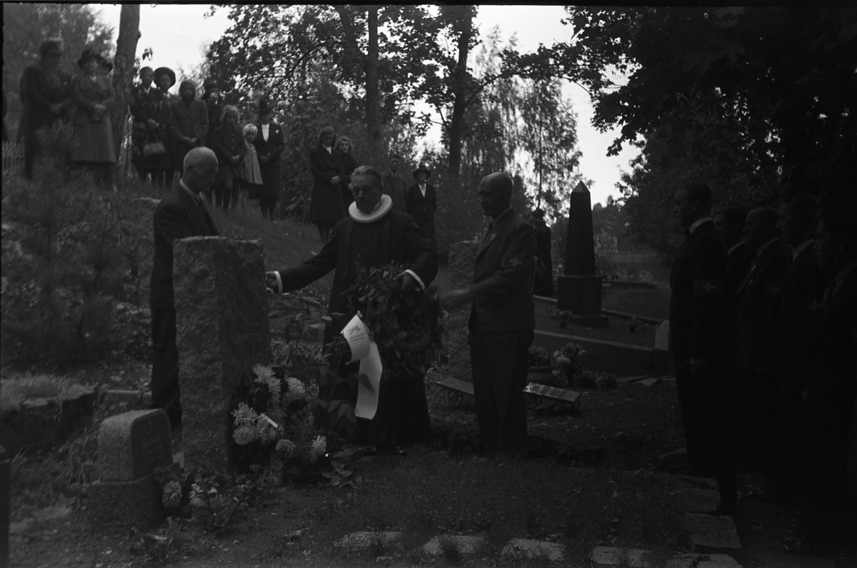 Fem bilder fra en høytidelighet på Hoff kirkegård, sannsynligvis 16. september 1945 som var en minnedag for de som falt under 2.verdenskrig.. Markering foregår sannsynligvis ved graven til Bjarne Fodstad som falt ved Haug kirke i Vardal 21.april 1940. Prosesjonen utgjøres av, foruten sogneprest Ingebrigt Hole, medlemmer av Milorg-gruppa Kapp/Lena. På bilde nr. 1 er også følgende personer identifisert: Johan Nygaard i venstre bildekant, Carsten Aschim bakerst i rekka nærmest Nygaard, og trolig Harald Tørnby som nr. 2 i rekke nr. 2.
