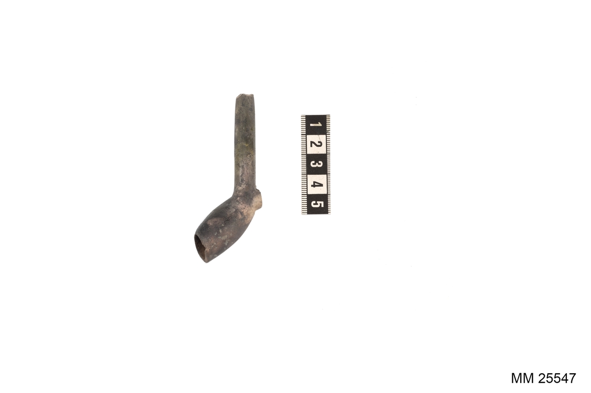 Brungrå kritpipa. Avbrutet skaft. Relativt stor klack på undersidan innan skaftet svänger till huvud och kammare.