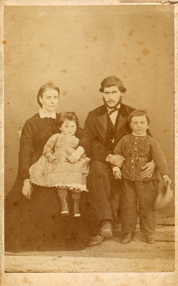 Portrett. Gruppe. Familiefoto. Mor, far og to barn. Baker Pedersen med familie.