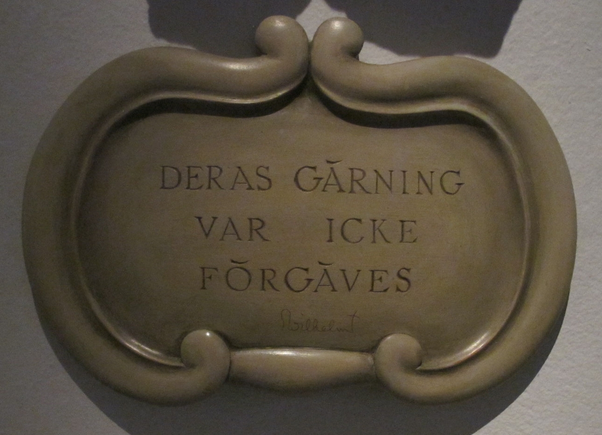 En sjöman med naken överkropp stående på vrakspillra och lyftande medvetslös kamrat ur skummande vågor. Nederst en bruten mast och upptill måsar.