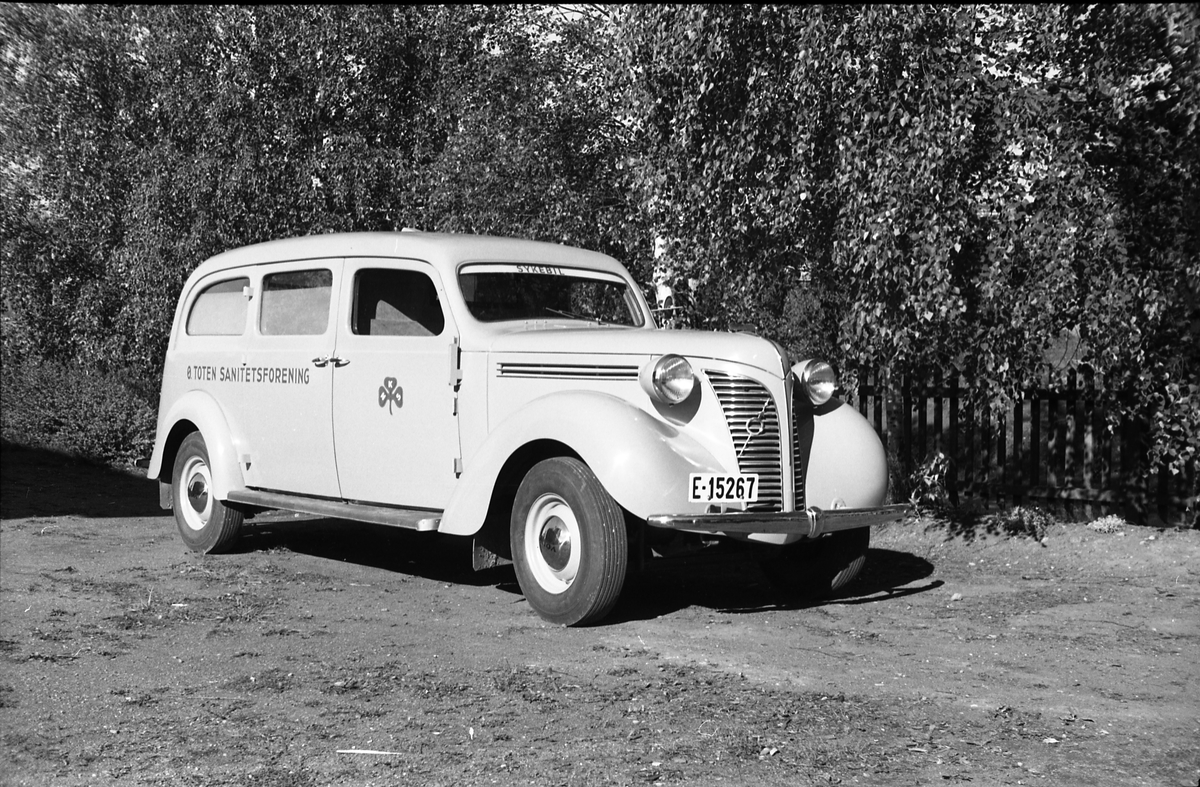 Ambulanse, muligens den første anskaffet av Østre Toten Sanitetsforening. Serie på 12 bilder fra september 1948. Kvinnen på bilde nr. åtte er Gjertrud Solem som trolig er sanitetsforeningens representant, mens mannen på bilde nr. sju, og som nok er sjåføren, er Anders Skolby fra Kapp. Han ble senere sjåfør for kronsprins Olav på Skaugum, og etter det privatsjåfør for Anders Jahre .