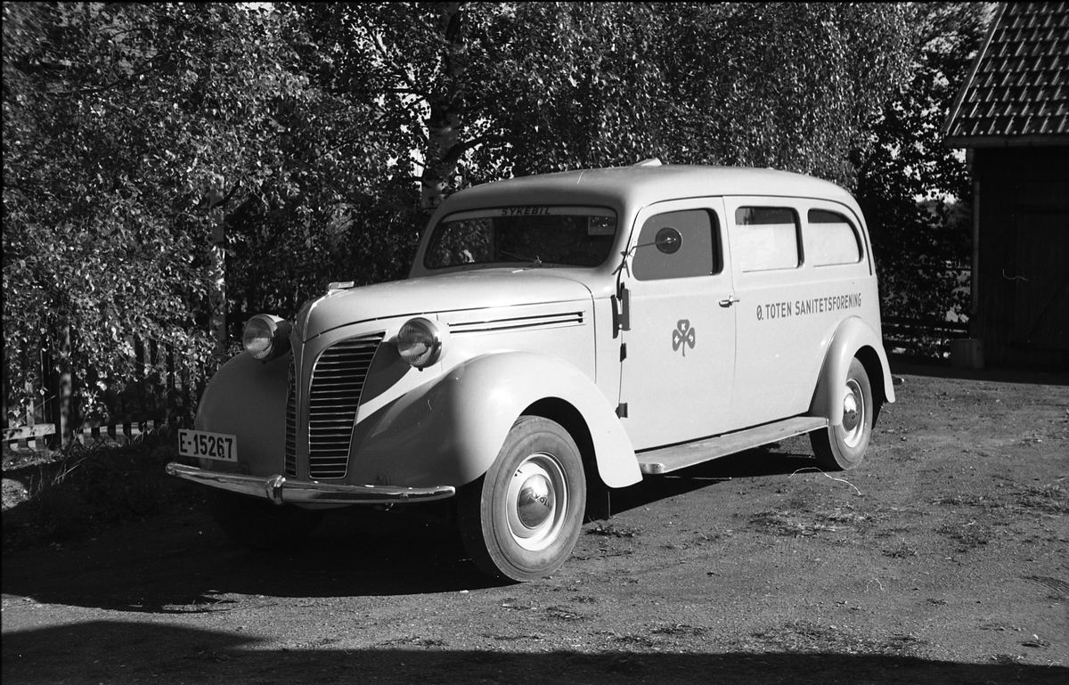 Ambulanse, muligens den første anskaffet av Østre Toten Sanitetsforening. Serie på 12 bilder fra september 1948. Kvinnen på bilde nr. åtte er Gjertrud Solem som trolig er sanitetsforeningens representant, mens mannen på bilde nr. sju, og som nok er sjåføren, er Anders Skolby fra Kapp. Han ble senere sjåfør for kronsprins Olav på Skaugum, og etter det privatsjåfør for Anders Jahre .