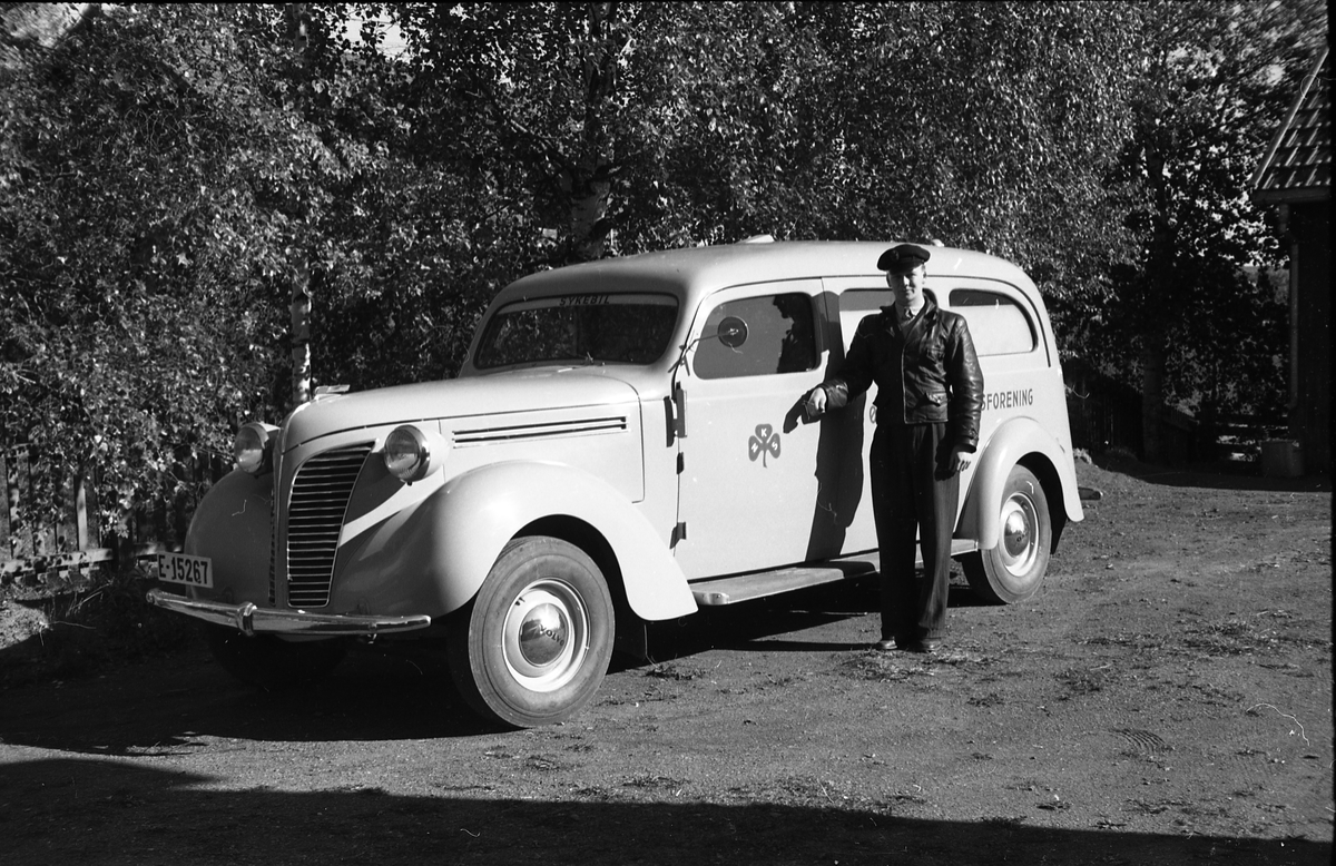 Ambulanse, muligens den første anskaffet av Østre Toten Sanitetsforening. Serie på 12 bilder fra september 1948. Kvinnen på bilde nr. åtte er Gjertrud Solem som trolig er sanitetsforeningens representant, mens mannen på bilde nr. sju, og som nok er sjåføren, er Anders Skolby fra Kapp. Han ble senere sjåfør for kronsprins Olav på Skaugum, og etter det privatsjåfør for Anders Jahre .