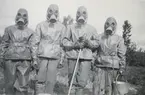 Gruppbild med soldater från Södermanlands regemente I 10 klädda i gasmask och skyddskläder.