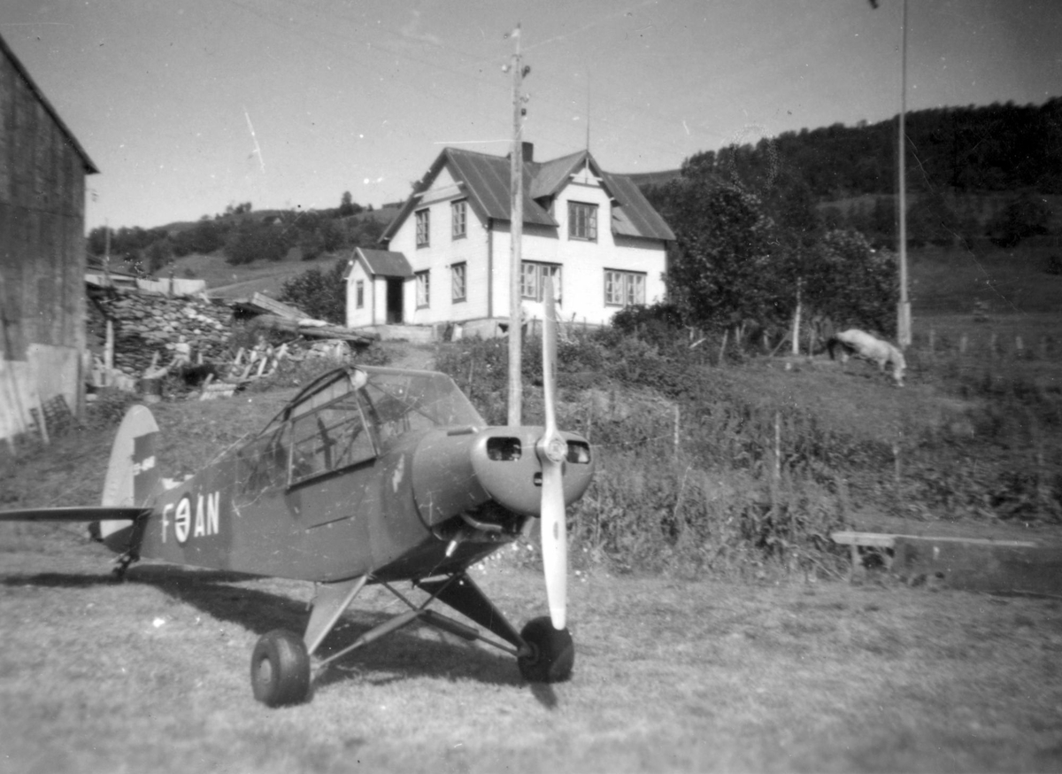 Fly på flystripa i Kaltdalen. Hus i bakgrunnen.