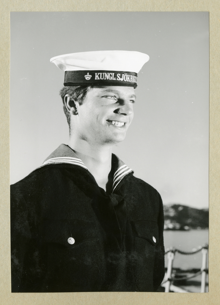 Bilden föreställer Carl XVI Gustaf klädd i mörk uniform. Bilden är tagen under minfartyget Älvsnabbens långresa 1966-1967.