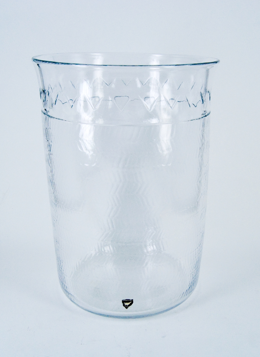 Vas i kristall. Orrefors glasbruk, design Gunnar Cyrén. Närmast cylindrisk, överst något utsvängd. Blank gravyr, fiskbensmönster. Märkt under: Orrefors Cyrén Expo 49-60 P.