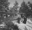 Flygplan Waco ZQC-6 mekas vid värn, vid F 19, Svenska frivilligflottiljen i Finland. Tre militärer vid flygplansmotorn.