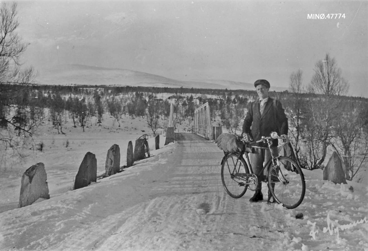Magnus Ryen med sykkel og Bredalslibrua i bakgrunnen. 