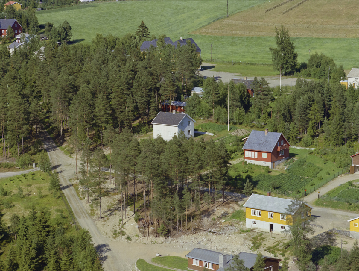 Øyer, Tretten østside. Kjørkevegen går fra nederst i billedkant opp til venstre. Furuskog og tre privatboliger. Det gule huset i høyre, nedre billedkant med hvit grunnmur er antakelig Bekkevegen 3, som går ut fra Kjøkevegen, venstre i bilde.