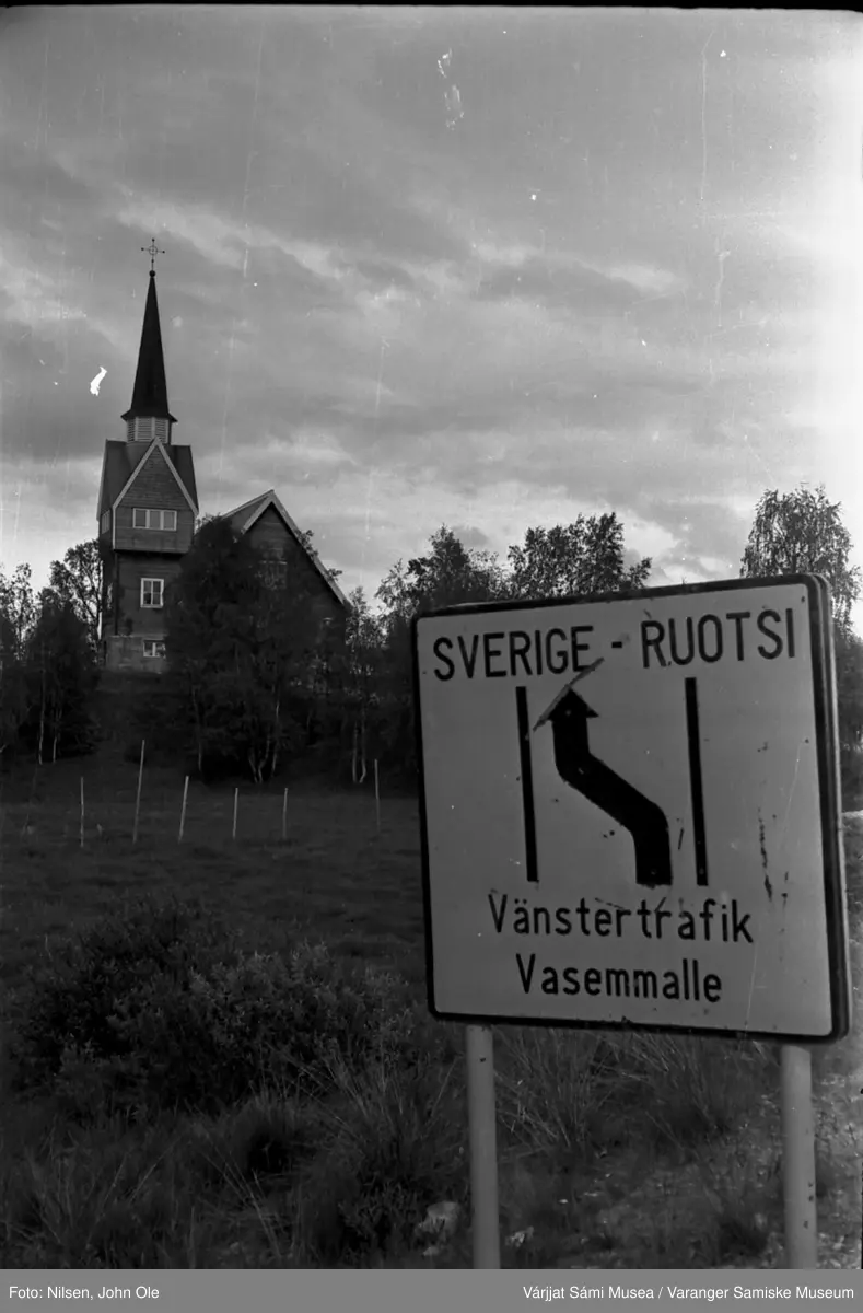 Karesuando kirke, grensen mellom Finland og Sverige. Veiskilt i forgrunnen som minner om at det er venstrekjøring i Sverige. Juli 1967.