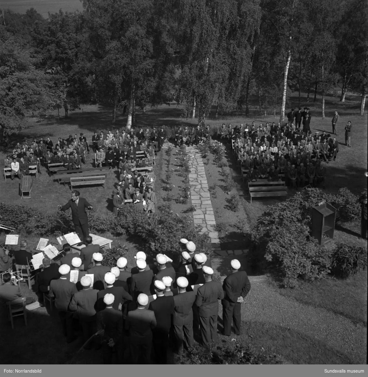 Tunadals sågverks hundraårsjubileum firas vid Tunadals herrgård. Stor publik i parken med tal av bland andra Axel Enström, förtäring, serveringspersonal och jubileumscigarrer.