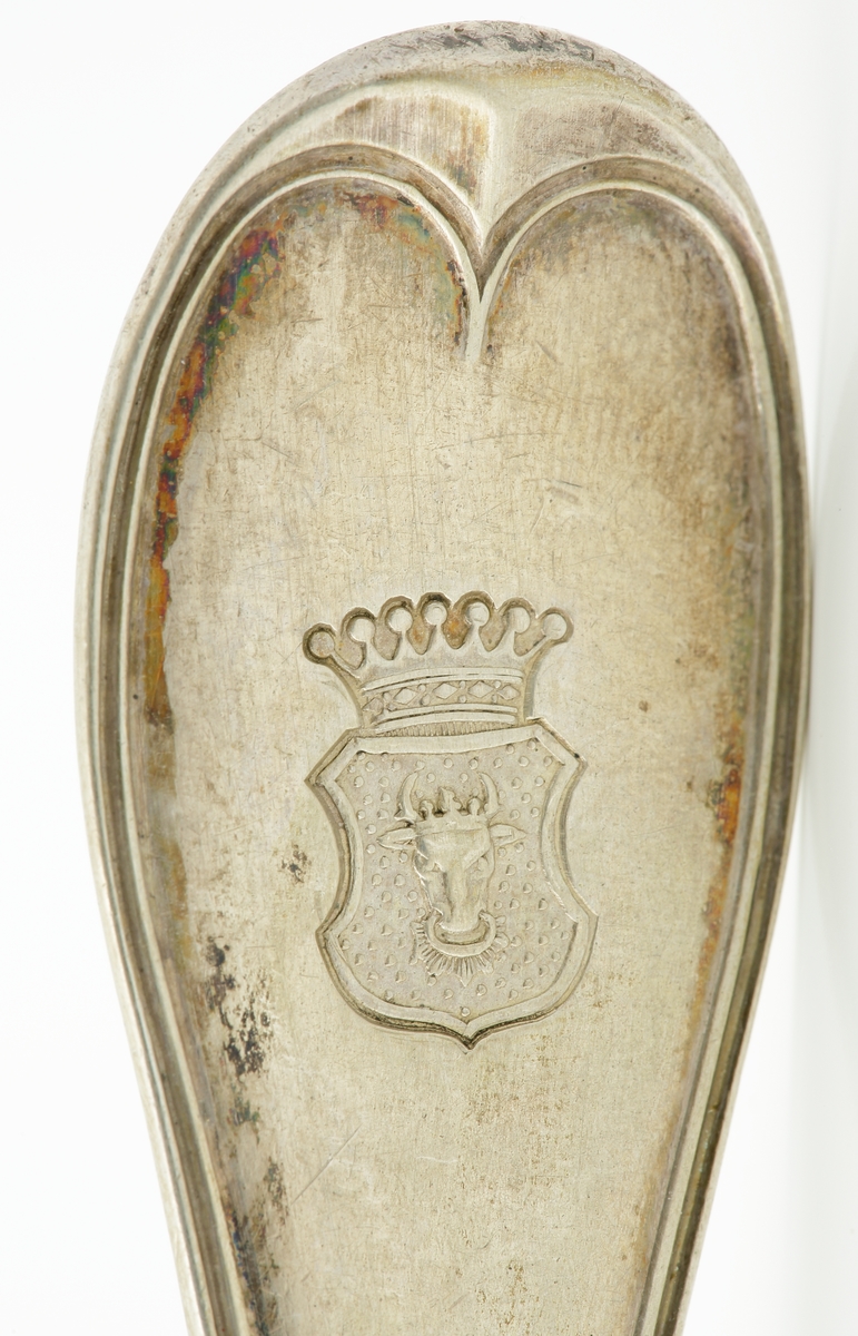 Matgaffel i silver.
Svensk trubbig modell. Präglat adelsvapen (friherrekrona med hjärtvapen i form av oxhuvud)* på skaftet.

*Friherrliga ätten von Mecklenburg (ointroducerad tysk/svensk adel).