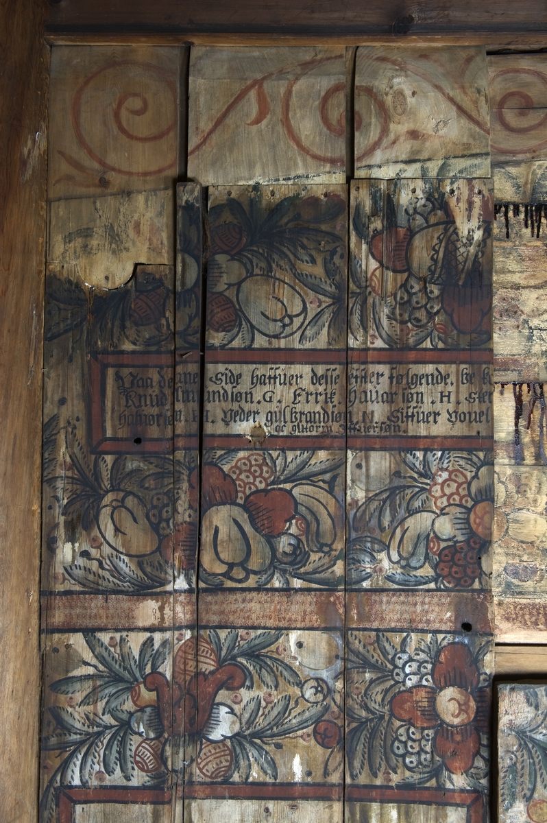 Malt blomsterdekor, tekst og navn på givere. Veggmalerier med religiøse motiver, datert 1652, fra apsis i Gol stavkirke på Norsk Folkemuseum.