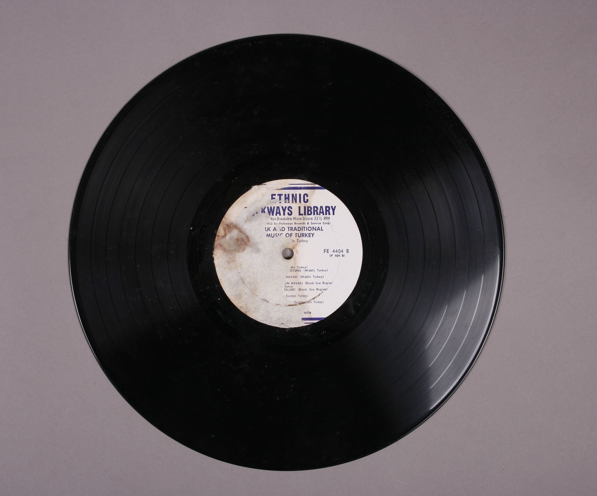 Grammofonplate i svart vinyl. Plata ligger i en papirlomme med påskriften "Trykia 4404". Ligger ved to identiske hefter, hvor på det ene har noe håndskreven påskrift (se bilde).