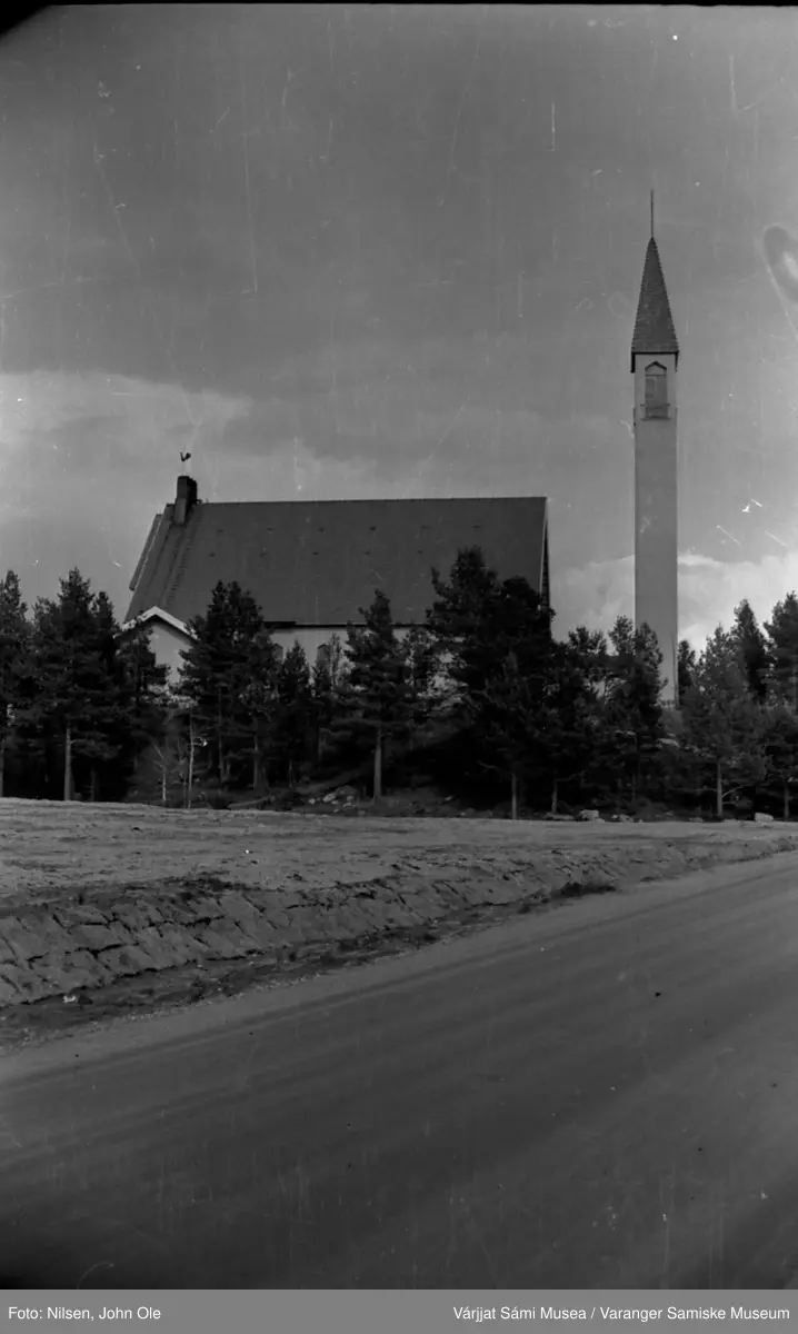 Enontekiö kirke i Hetta. Vei i forgrunnen, en del furutrær rundt kirkebygget. 16. juli 1967