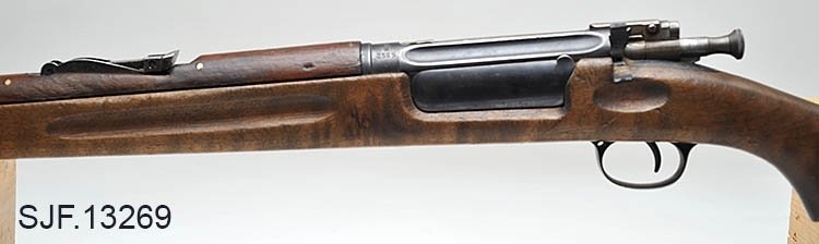 Krag-Jørgensen rifle med kaliber 6, 5 x 55. Geværet har pistolgrep. Magasinkapasitet på 5 patroner. Kolben er brunbeiset / oljet. Kolbekappe av stål. På munningen er det festet ei messinghette, en snø- og vannbeskytter. Geværet er utstyrt med høydejusterbart skur og sidejusterbart korn. 
Det er bærereim påmontert geværet. 