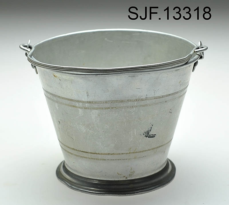 Bærspann i aluminium. Spannet har en fot som er noe breiere enn spannets bunn, og det er preget inn 4 striper langs spannets utside. Det er festet en bærehank til spannet. 

Spannet er brukt av giver da hun var ei lita jente, og av hennes mor som var født ca. 1910. Spannet ble brukt på bærtur. Giver forteller at det til sammen har blitt båret mange hundre kilo blåbær i dette lille spannet. Plukkested var først i Heradsbygda, og deretter Jømna. 
