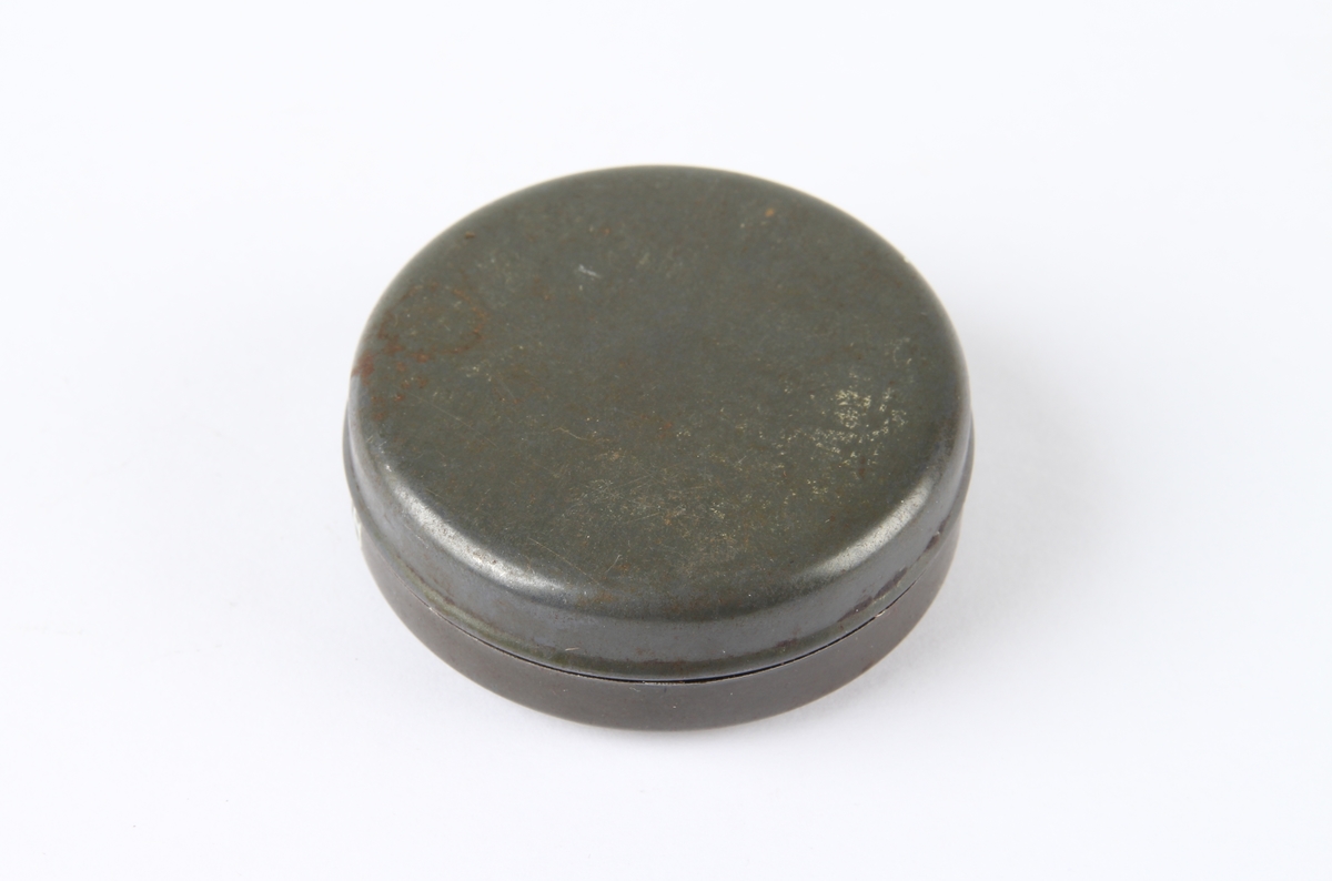 Vaselinboks med lokk og logo.