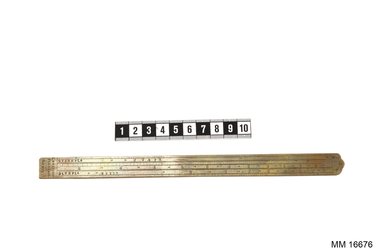 Linjal liknande måttstock i mässingsblankt utförande. På ena sidan: graverad med sifferskalor, styckmynning, tum, "jernkula" samt i änden Carl XI:s krönta namnchiffer samt årtalet 1689. På andra sidan: sifferskalor, stenkula, blykula samt i änden "Christopp Polhammar Dorpt".