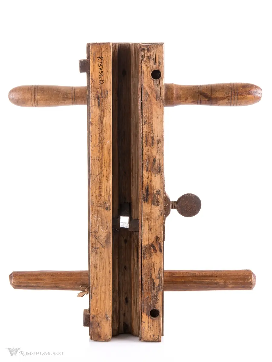 Rektangulær okshøvel med jern og kile. Jernet kan reguleres med skrumekanisme. Et dreid og et skåret håndtak er felt ned i avrundede spor foran og bak. Spor for høvling av fjær i sålen og regulerbare styringslister på hver side av sporet.