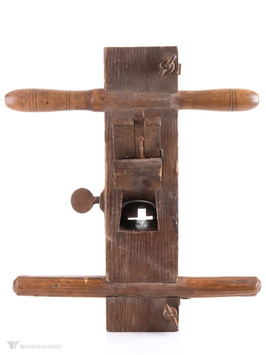 Rektangulær okshøvel med jern og kile. Jernet kan reguleres med skrumekanisme. Et dreid og et skåret håndtak er felt ned i avrundede spor foran og bak. Spor for høvling av fjær i sålen og regulerbare styringslister på hver side av sporet.